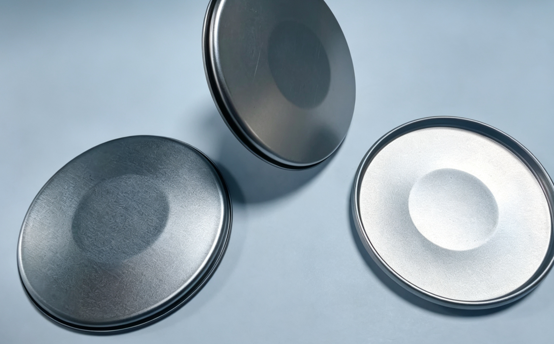 Three round deep-drawn end covers showing the outer face and the inner recess